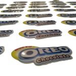 Dome adhesivo de resina epóxica troquelado a la forma del logo — PinsPro Chile
